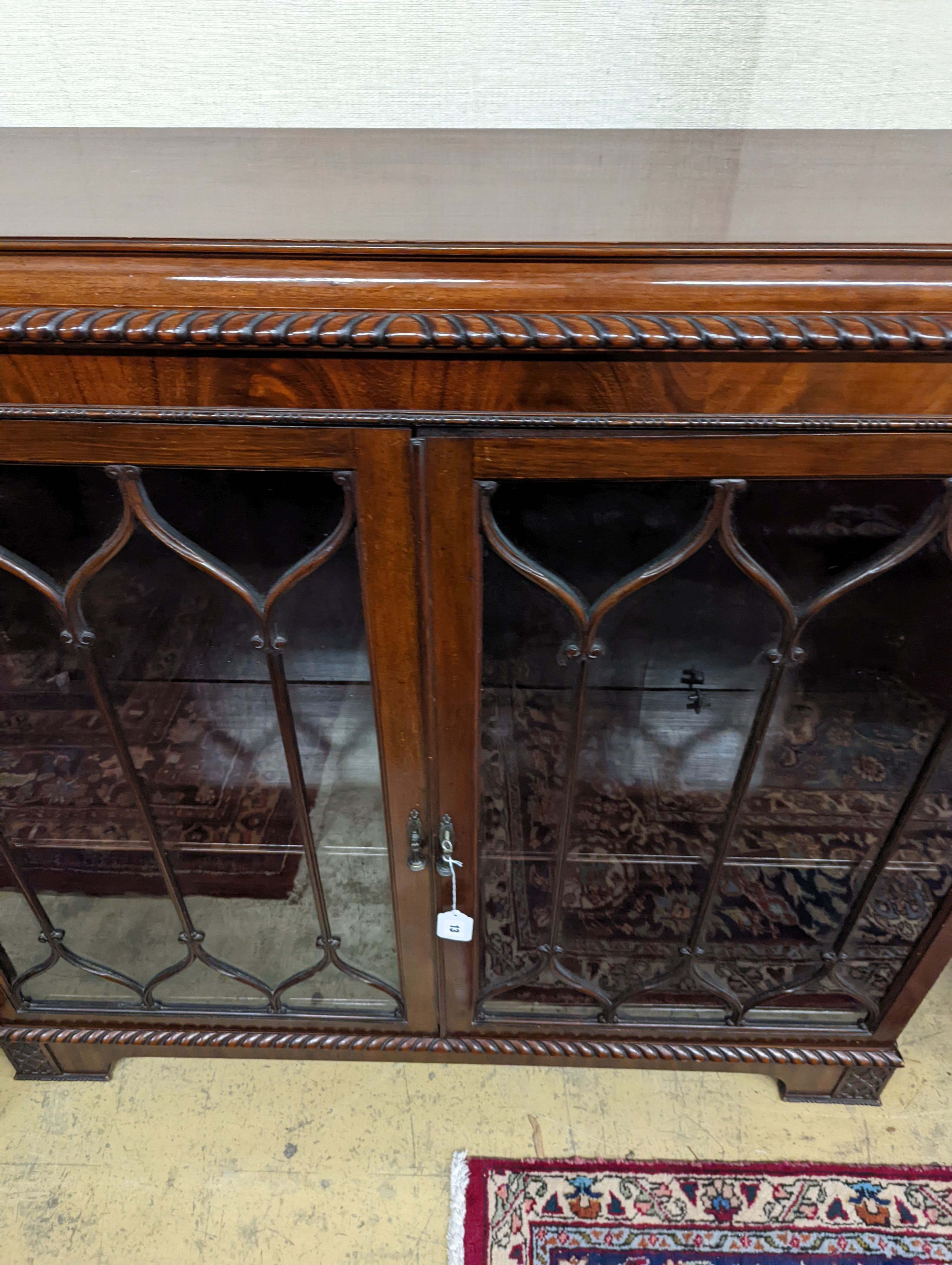 A 1920s mahogany low bookcase, in Chippendale style W-118cm, D-34cm, H-112cm.